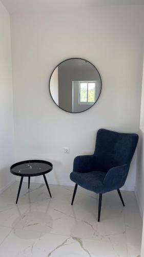 a blue chair and a table and a mirror at Palma Village by Greek Pride Hotels in Skála Foúrkas