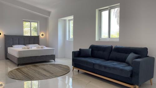 a living room with a couch and a bed at Palma Village by Greek Pride Hotels in Skála Foúrkas