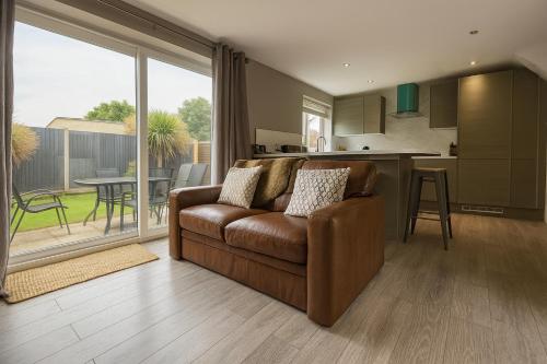 a living room with a brown couch and a kitchen at 1 bed - Sleeps3 - Free Parking - 5 min to centre in Lincoln