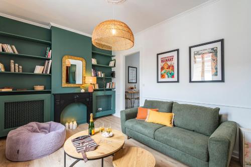 un salon avec un canapé et une table dans l'établissement La Fine Bulle, Appartement de Charme au cœur de Reims, à Reims