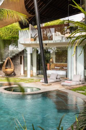 a house with a swimming pool in front of a house at Villa Toraja in Canggu