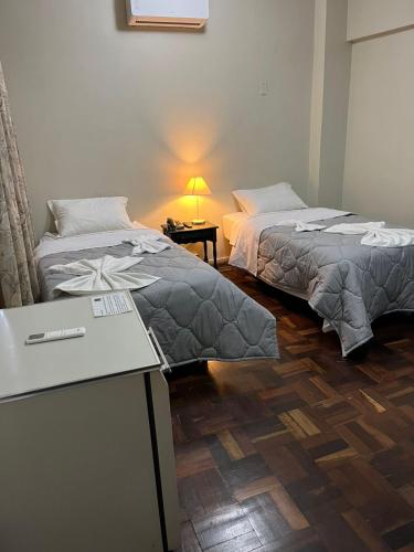 two beds sitting next to each other in a room at Hotel Ponta Grossa São Marcos in Ponta Grossa