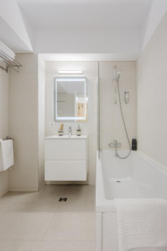 a white bathroom with a sink and a shower at City Center Accommodation 210 in Reşiţa