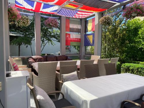 a restaurant with tables and chairs and flags on a patio at Bortnichi House in Kyiv