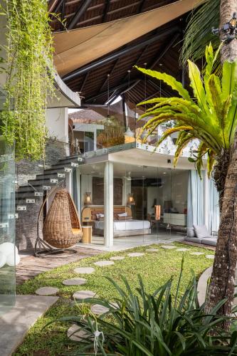 a house with a staircase in the middle of a yard at Villa Toraja in Canggu