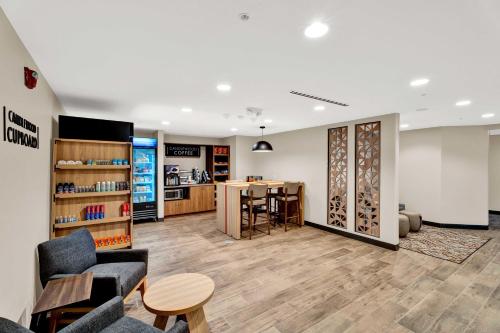 a waiting room with chairs and a table and a counter at Candlewood Suites - Detroit - Auburn Hills by IHG in Auburn Hills