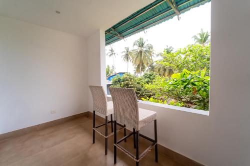 a table and chairs in a room with a window at Rococo mandrem beach resort in Old Goa