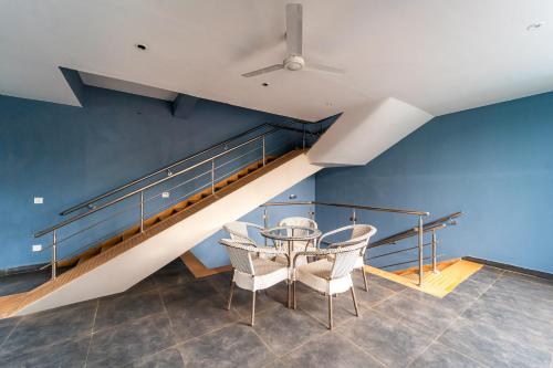 a dining room with a table and chairs and a staircase at Rococo mandrem beach resort in Old Goa