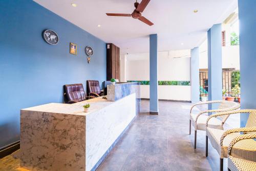 a lobby with blue walls and a counter with chairs at Rococo mandrem beach resort in Old Goa
