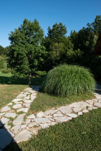 a stone path in a yard with a tree at Plitvice Inn in Jezerce