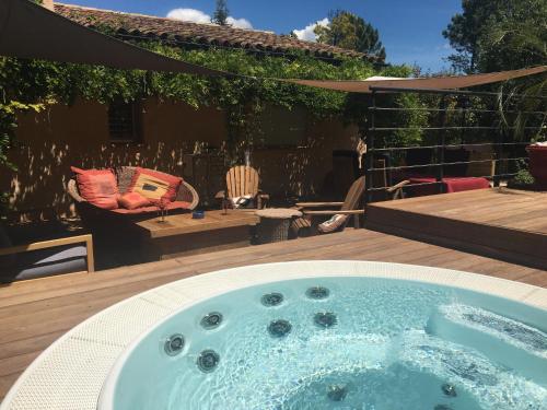 a jacuzzi tub on a deck in a yard at Bulle d'amour in Montauroux