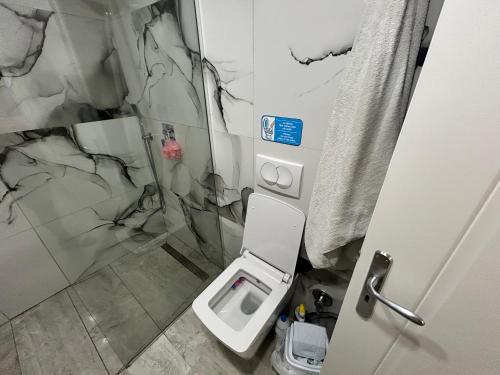 a bathroom with a toilet and a marble wall at Hilltop Villa in Shetaj