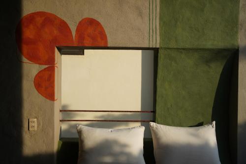 a bed with two pillows in a room at Dechiu in Hoi An