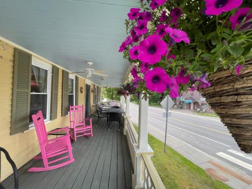 a porch with pink chairs and tables and flowers at Jamaicahaus in Jamaica