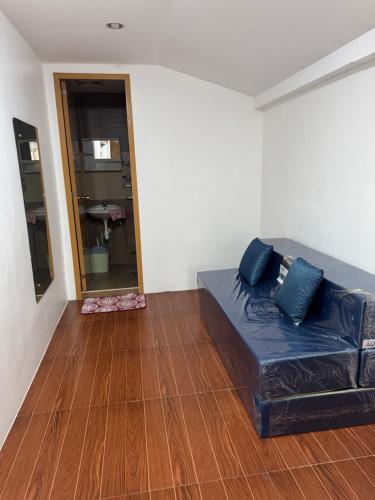 a black couch in a room with a wooden floor at E and R apartment in Clarin