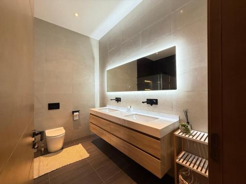 a bathroom with a sink and a toilet and a mirror at R&R Homes in Kwedonu