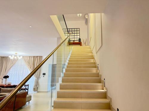 a staircase in a house with glass railing at R&R Homes in Kwedonu