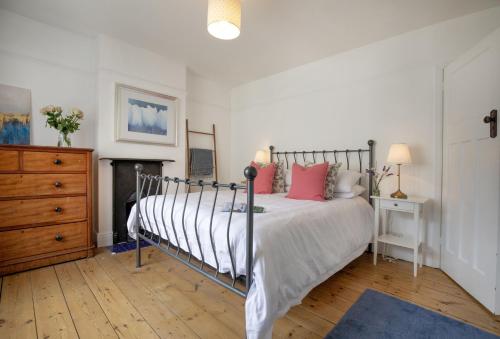 a bedroom with a bed with pink pillows on it at Withycombe in Seaton