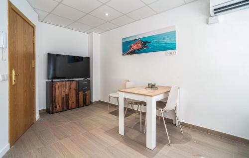 a dining room with a table and a television at 1 Bedroom Stunning Apartment In Grao De Castellon in Grao de Castellón