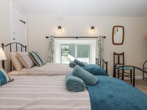 a bedroom with two beds with blue pillows at Aunty Junes Cottage in Okehampton
