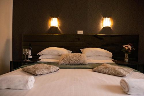 a bed with two pillows and two lights on the wall at Plitvice Inn in Jezerce