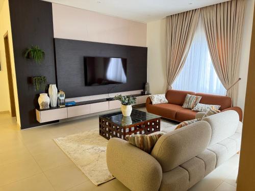 a living room with a couch and a tv at R&R Homes in Kwedonu