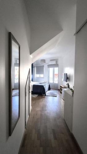 a white room with a bed and a mirror at Bee Invitee - Alojamento Local in Amarante