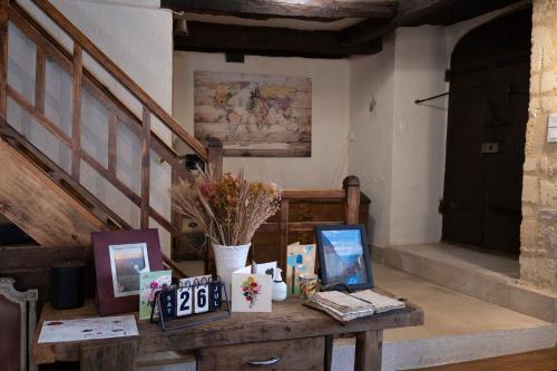a table with pictures on it in a room with stairs at Les Petits Cousins Du Québec - Chambres D’hôtes à Domme in Domme