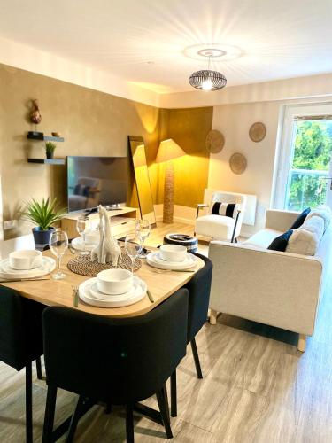 a dining room table with chairs and a living room at Safari 2 Bedroom Condo with Free Secure Parking in Manchester