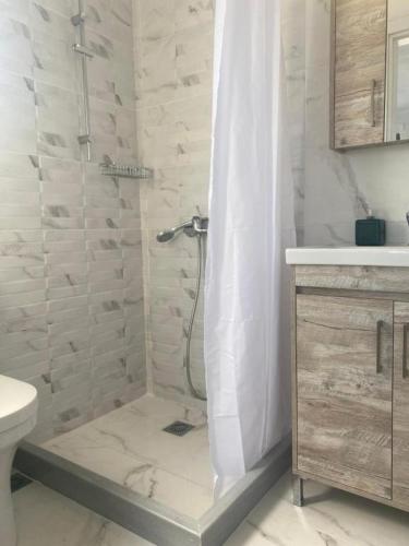 a white bathroom with a shower and a toilet at Maurizio's Villa in Yiáltra