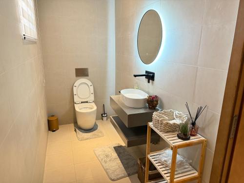a bathroom with a toilet and a sink and a mirror at R&R Homes in Kwedonu