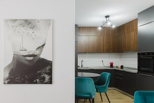 a kitchen with blue chairs and a picture of a woman at City Center Accommodation - 410 in Reşiţa