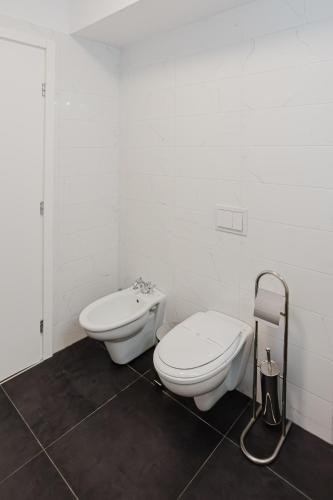 a white bathroom with a toilet and a bidet at City Center Accommodation - 410 in Reşiţa