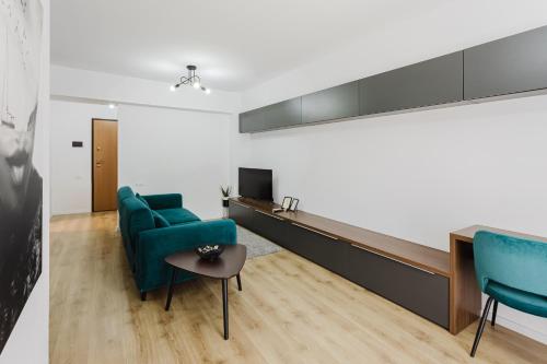 a living room with two blue chairs and a table at City Center Accommodation - 410 in Reşiţa