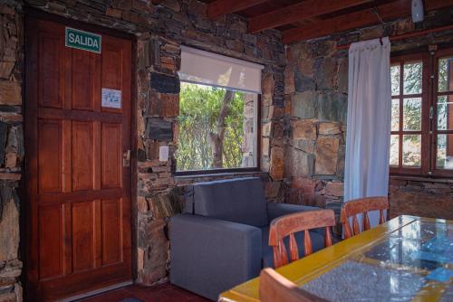 a living room with a door and a couch and a table at Amanecer en las Piedras in Tandil