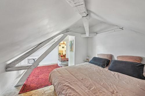 a bedroom with a bed in a white room at Maison Mahaut in Beauchamps-sur-Huillard
