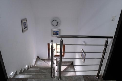 a stairway with a clock on the wall and a clock at Plitvice Inn in Jezerce