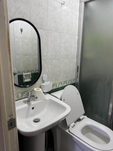 a bathroom with a sink and a toilet and a mirror at E and R apartment in Clarin