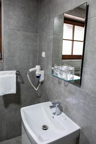 a bathroom with a white sink and a mirror at Plitvice Inn in Jezerce