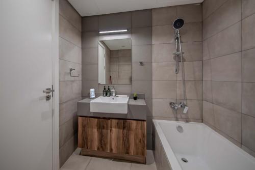 a bathroom with a sink and a bath tub at 2BHK Family Apartment in Al Mamsha, Sharjah in Sharjah