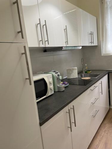 kuchnia z białymi szafkami i mikrofalówką w obiekcie Il Mughetto w mieście Lecco