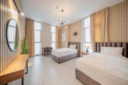 a hotel room with two beds and a desk at 2BHK Family Apartment in Al Mamsha, Sharjah in Sharjah