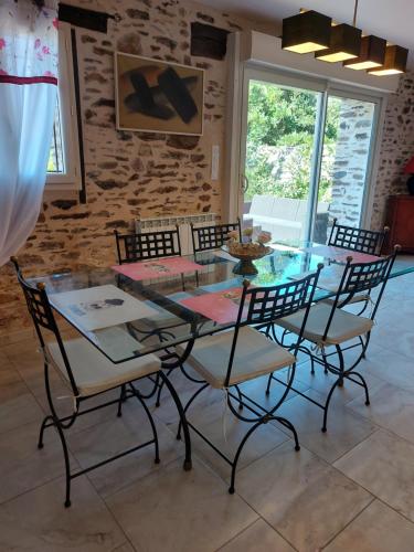 a dining room with a glass table and chairs at GITE de THOMAS in Sarlande
