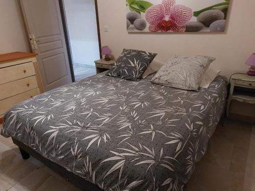 a bedroom with a bed with a black and white comforter at GITE de THOMAS in Sarlande