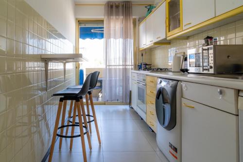 une cuisine avec un lave-linge et deux tabourets dans l'établissement Proche plages Parking Etage élevé Terrasse, à Antibes