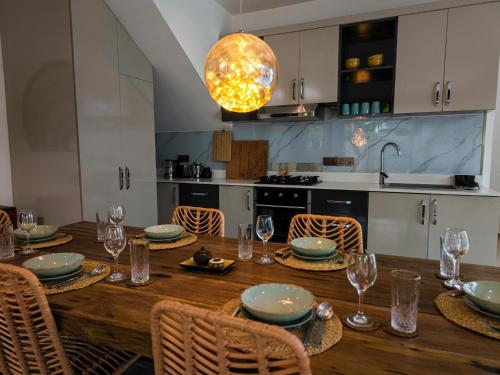 a kitchen with a wooden table with plates and glasses at Emerald Villas by Paje Emerald Escapes Ltd in Paje