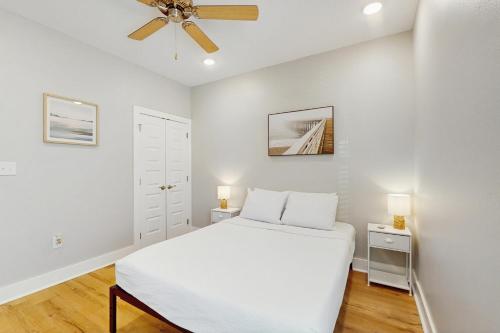 Un dormitorio blanco con una cama y un ventilador de techo. en Oasis Dream #193, en Rockport