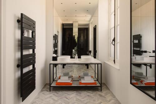 une salle de bain avec un lavabo et un miroir dans l'établissement Le Clos des Martines, Maison d'exception, à Écos