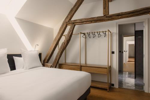 - une chambre avec un lit blanc et un couloir dans l'établissement Le Clos des Martines, Maison d'exception, à Écos