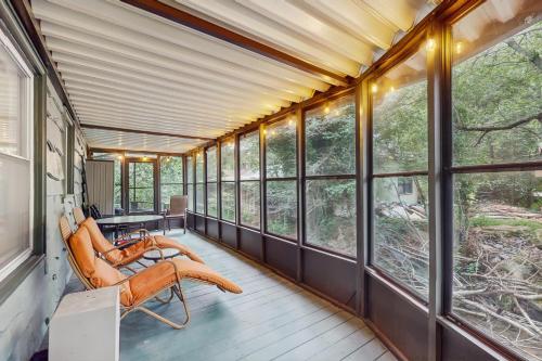 a screened in porch with chairs and windows at Bamboozled in Boone